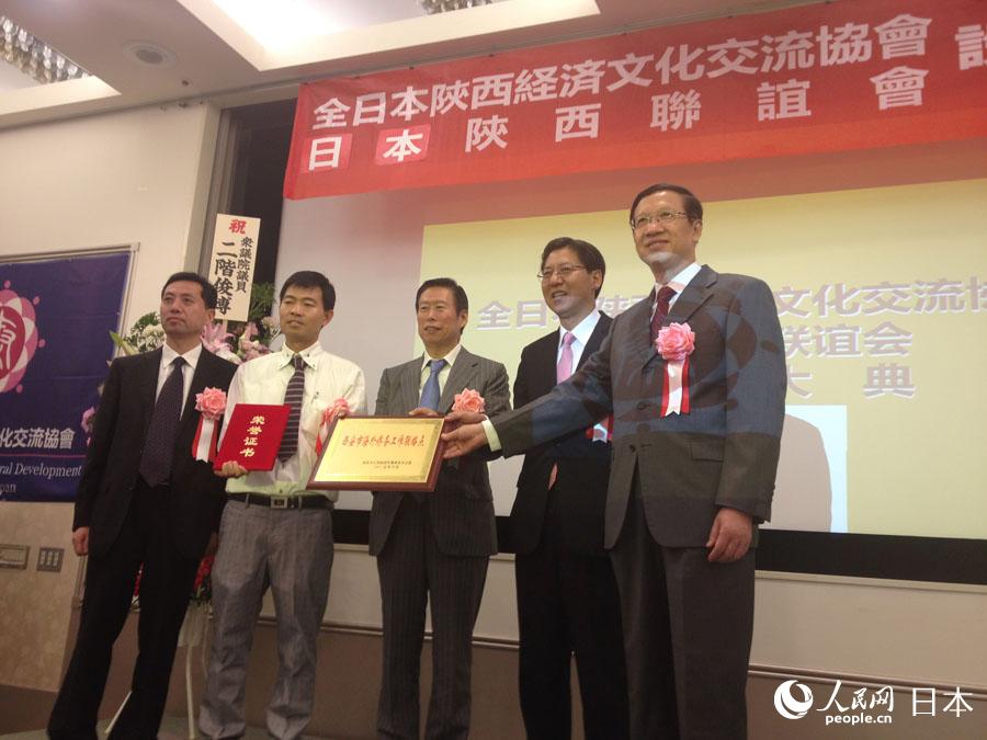 「全日本陝西経済文化交流協(xié)會」と「日本陝西聯(lián)誼會」の2団體に「西安市海外華僑事務(wù)工作連絡(luò)処」のプレートを授與する陝西省委員會統(tǒng)一戦線工作部の孫暁傑?常務(wù)副部長（右端）