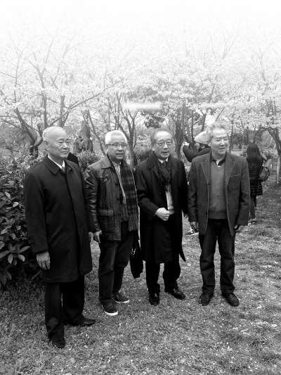 3月12日、堤角公園の桜の樹の下で記念撮影する4人。左から趙學東さん、朱漢順さん、村石久二さん、易望學さん。