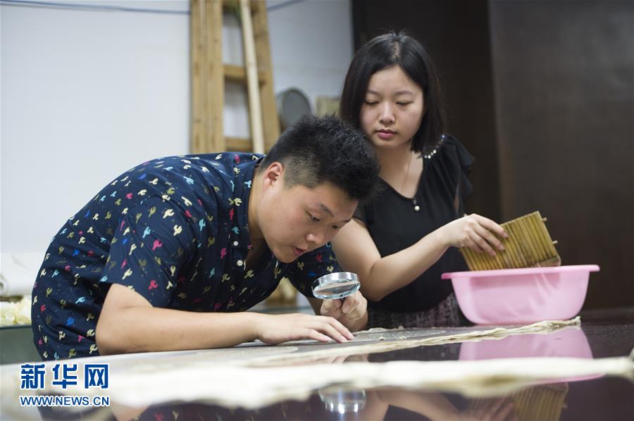 趙暁龍さんと妻の張暁ロウさんが文化財(cái)の修復(fù)を行なっている。