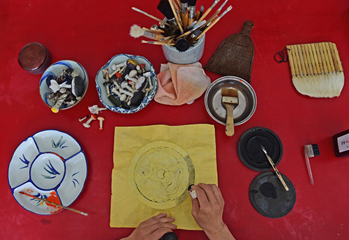 文化財(cái)保護(hù)技師の張啓剛さんが文化財(cái)の拓本をとっている。