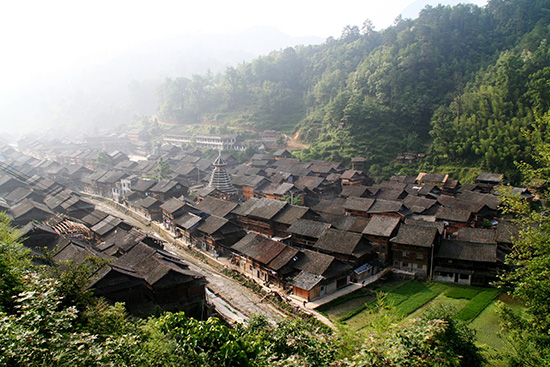 肇興　遠(yuǎn)景       貴州省　肇興  ★  肇興は、桂林と貴陽(yáng)を結(jié)ぶ國(guó)道の途中にあるトン族の村です。山奧の靜かな村に滯在し、トン族の文化や生活に觸れながら忙しい日々を忘れて心を癒やす。そんな楽しみ方です。★  トン族といえば、木造建築の技術(shù)にすぐれ、釘を1本も使わない鼓樓や風(fēng)雨橋が有名です。★  メイン通りには、レストランやバーや美容院もありますが、いずれも他の民家とたがわず木造で、看板も木製なのでよく見(jiàn)ないとそこが店であることに気が付きません。でも一歩入れば、木をうまく利用したおしゃれでモダンなインテリアとなっているお店もあります。★  観光客用の旅館もいくつかありますが、いずれも木造で高層の建物はなく、村の景色に溶け込んでいます。