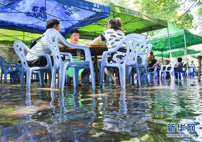 厳しい殘暑が続く重慶、涼を求めて水辺に集まる人々