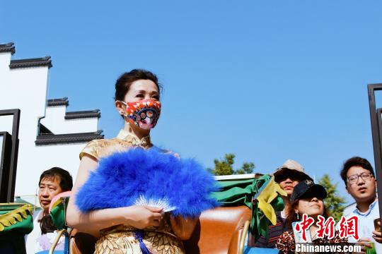 チャイナ?ドレス姿の「覆面」美女が颯爽と登場　ユニークな京劇マスクに熱視線