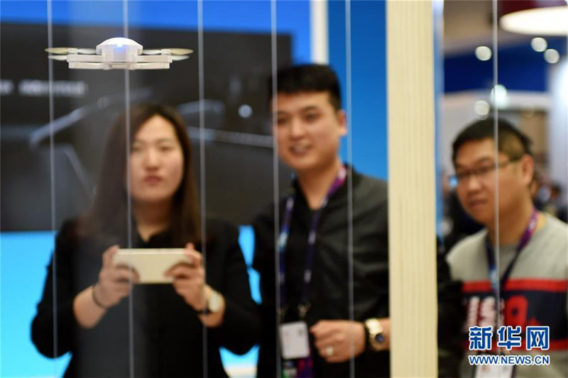 攜帯電話(huà)で小型ドローンを操作する來(lái)場(chǎng)者。