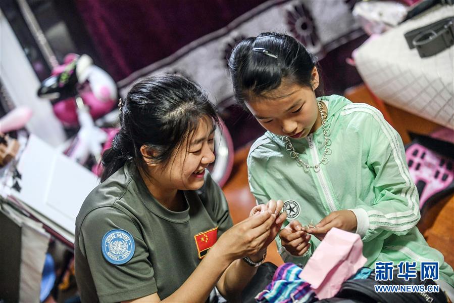 マリから買ってきたお土産を自分の娘に手渡す元瀋陽軍區(qū)総合病院放射線診斷科の張兵?主任技師（寫真左。5月18日、撮影?潘■龍、■は日かんむりに立）。