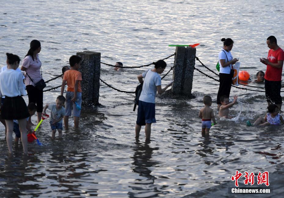 猛暑が続く廈門市、市民たちは海辺で水遊び