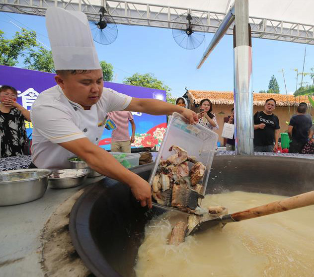 大鍋で魚(yú)の煮込み料理を観光客に振る舞うイベント 湖南省張家界