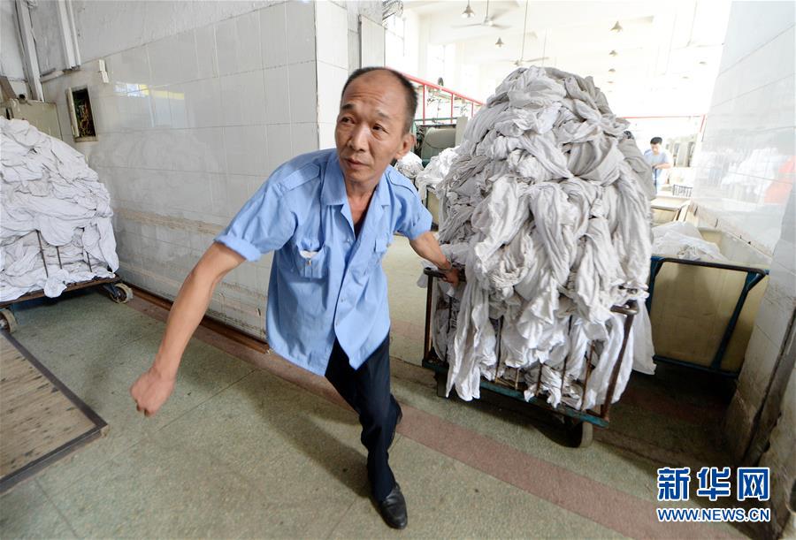 サウナのような暑さの中で働く寢臺(tái)列車リネン部門の作業(yè)員たち