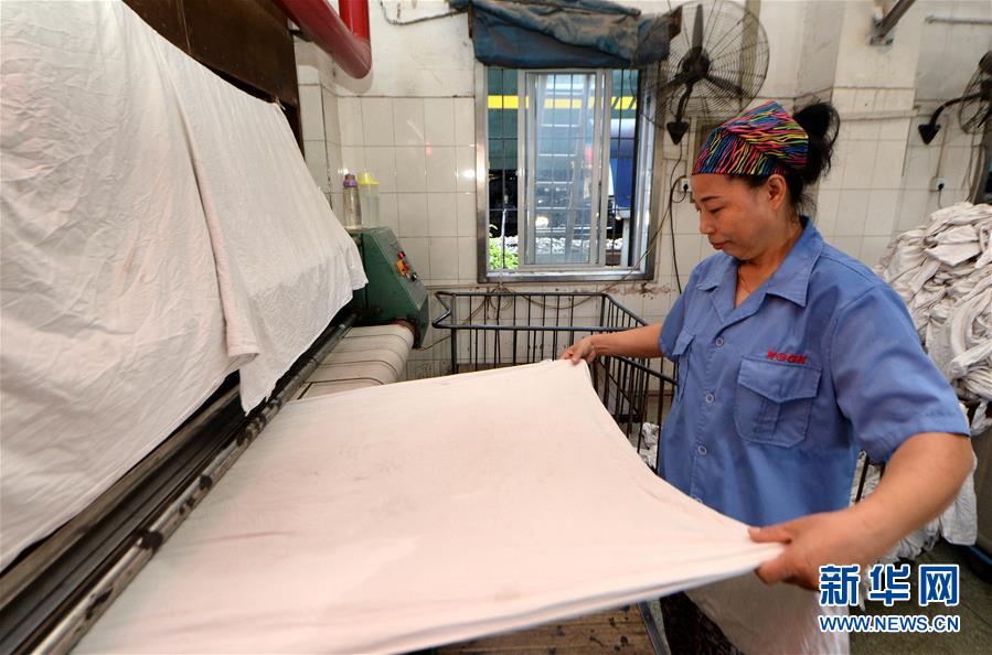 サウナのような暑さの中で働く寢臺(tái)列車リネン部門の作業(yè)員たち