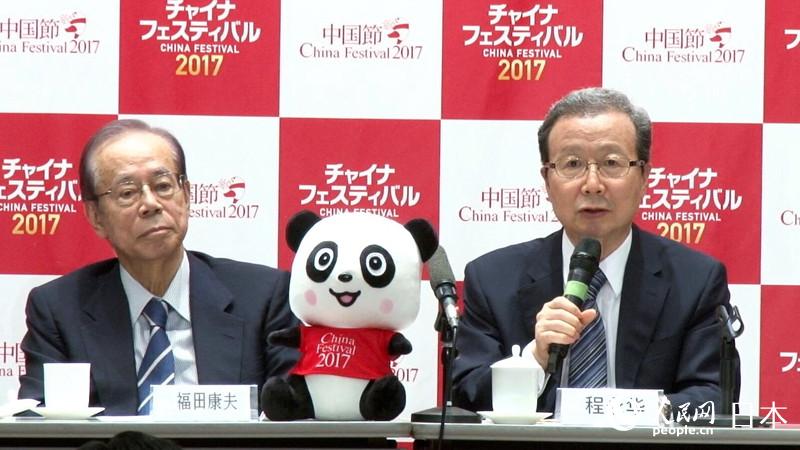 日本の福田康夫元首相（寫(xiě)真右）。中央には「2017チャイナフェスティバル」のパンダのマスコットキャラクターのぬいぐるみが置かれている。