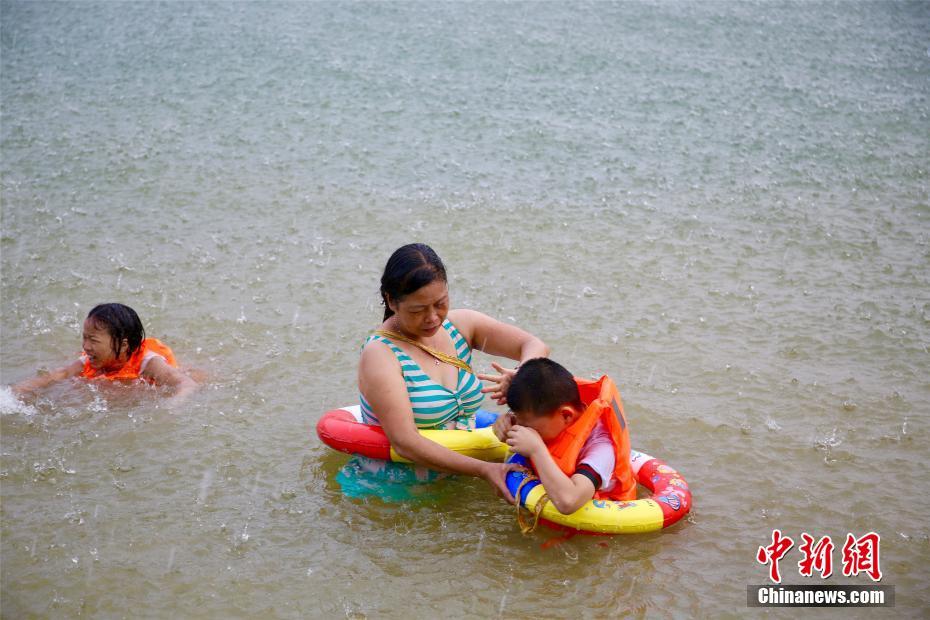 連日酷暑の広西チワン族自治區(qū)に「恵みの雨」、雨の中水遊びをする市民
