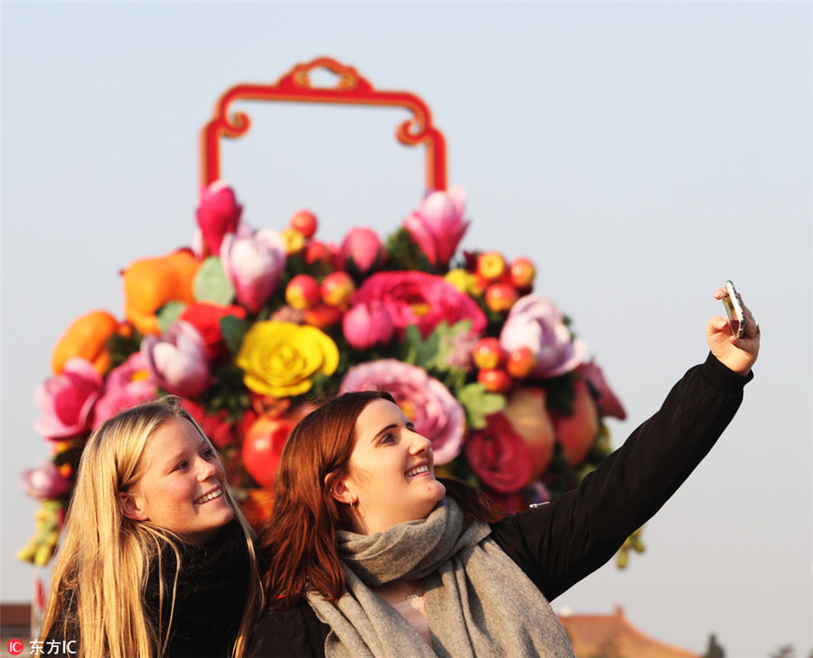 秋空をバックに天安門(mén)広場(chǎng)で記念撮影を楽しむ中國(guó)國(guó)內(nèi)外の観光客たち