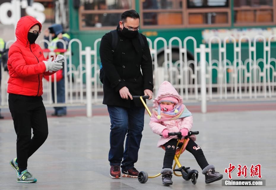 急激な気溫低下に見(jiàn)舞われた北京　完全防備で外出する市民　