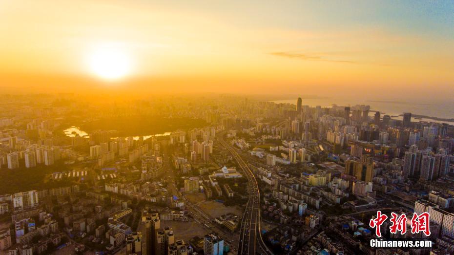 冬日の?？谑?、溫もり帯びた夕日が都市を照らす　海南省　