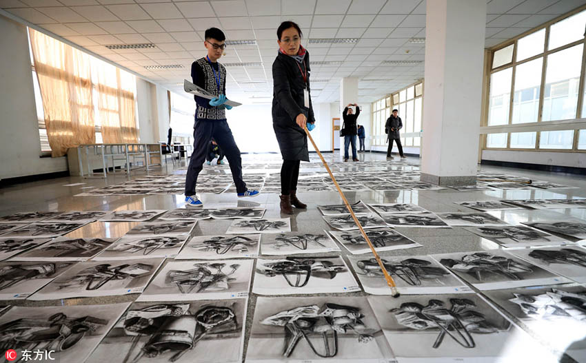 作品の山の中から優(yōu)秀作品を選ぶ美術(shù)大學(xué)統(tǒng)一試験の採(cǎi)點(diǎn)現(xiàn)場(chǎng)　山東省