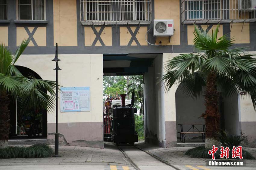 住宅用マンションの下をくぐって運(yùn)行する観光ミニ列車　重慶市