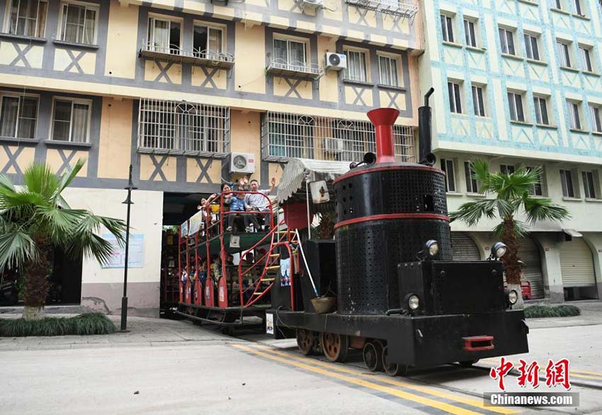 住宅用マンションの下をくぐって運行する観光ミニ列車　重慶市