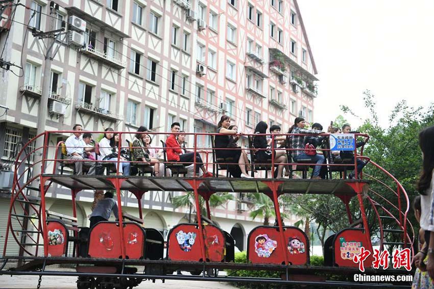 住宅用マンションの下をくぐって運(yùn)行する観光ミニ列車　重慶市