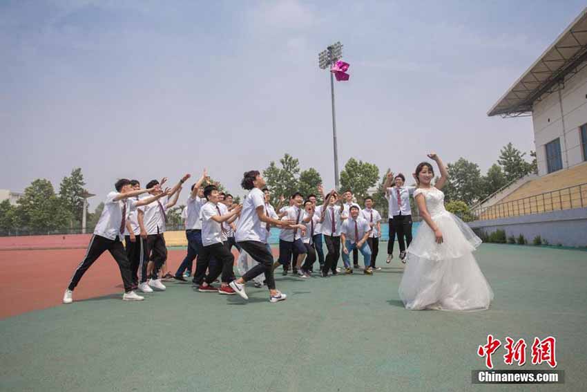 紅一點の女子學(xué)生、男子たち従えウェディングドレスで卒業(yè)寫真　山東省