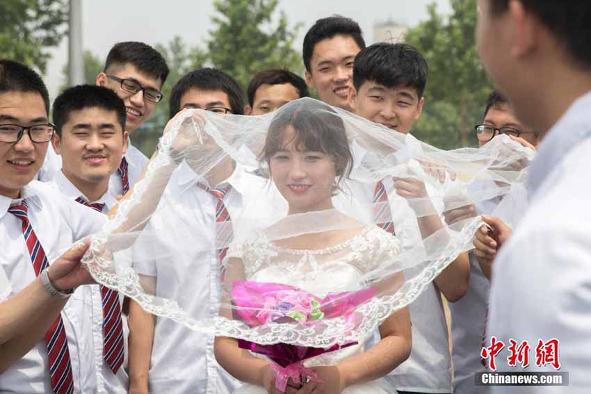 紅一點の女子學(xué)生、男子たち従えウェディングドレスで卒業(yè)寫真　山東省