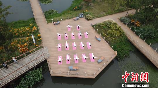 揚州市の景勝地でハスの花に囲まれながらヨガパフォーマンス