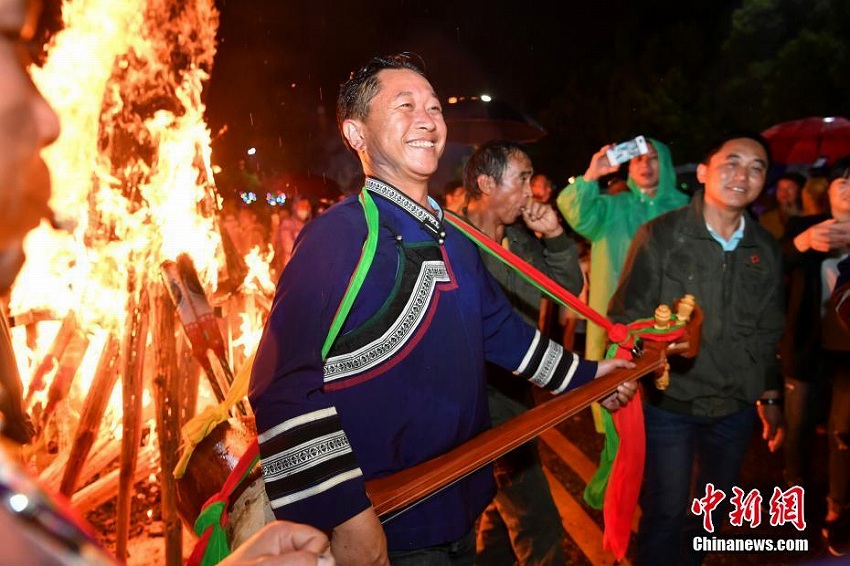 雨の中、「松明祭」を祝い歌って踴るイ族の人々　雲(yún)南省昆明市