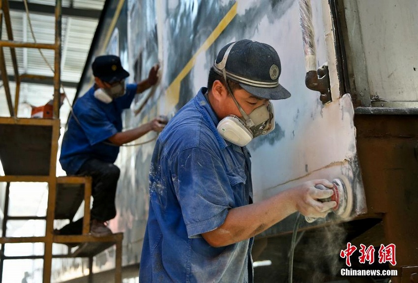 猛暑の中、刷毛を手に列車をリニューアルする「美容師」たち