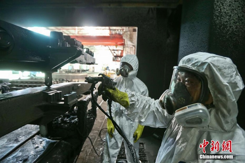 猛暑の中、刷毛を手に列車をリニューアルする「美容師」たち