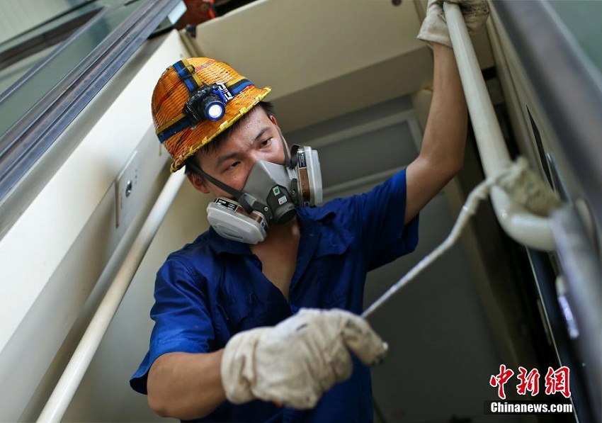 猛暑の中、刷毛を手に列車をリニューアルする「美容師」たち