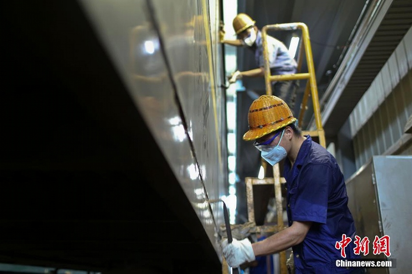 猛暑の中、刷毛を手に列車をリニューアルする「美容師」たち