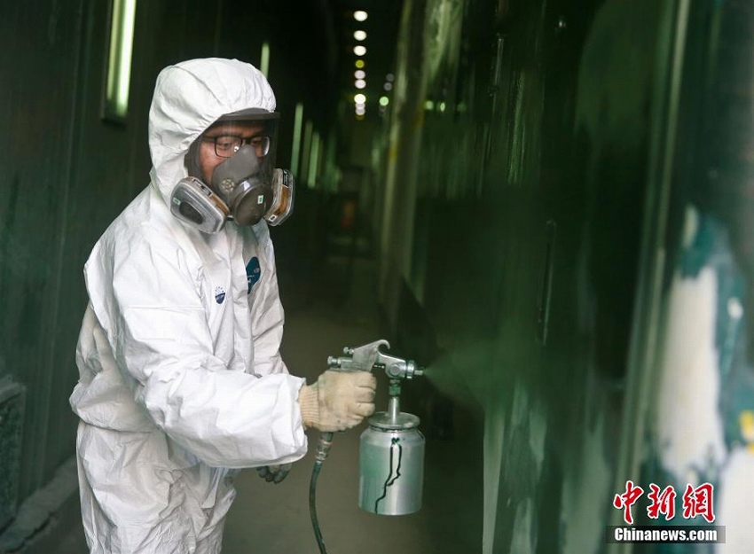 猛暑の中、刷毛を手に列車をリニューアルする「美容師」たち