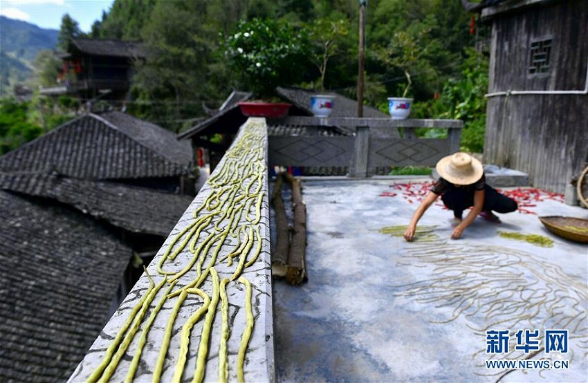 吊腳樓の軒下埋め盡くす秋の実りの天日干し　湖北省
