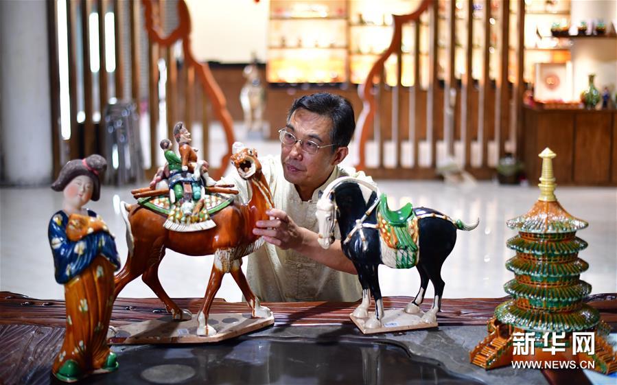 唐三彩の作品に目を向ける唐三彩焼き上げ技術(shù)の代表的な伝承者である高水旺さん。