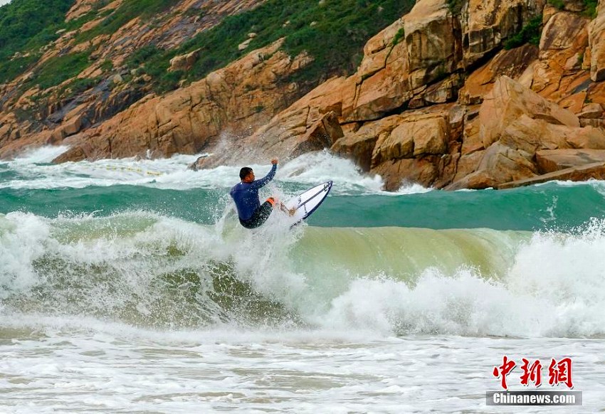 香港で強風警報、高波を楽しむサーファーたち