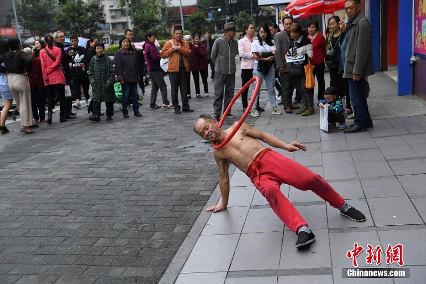 愛犬と街中でパフォーマンスを披露する75歳男性　重慶市

