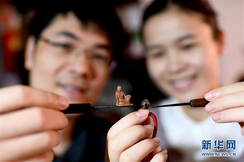 夫婦仲良く彫刻刀を手に無形文化財の木彫刻技法を伝承