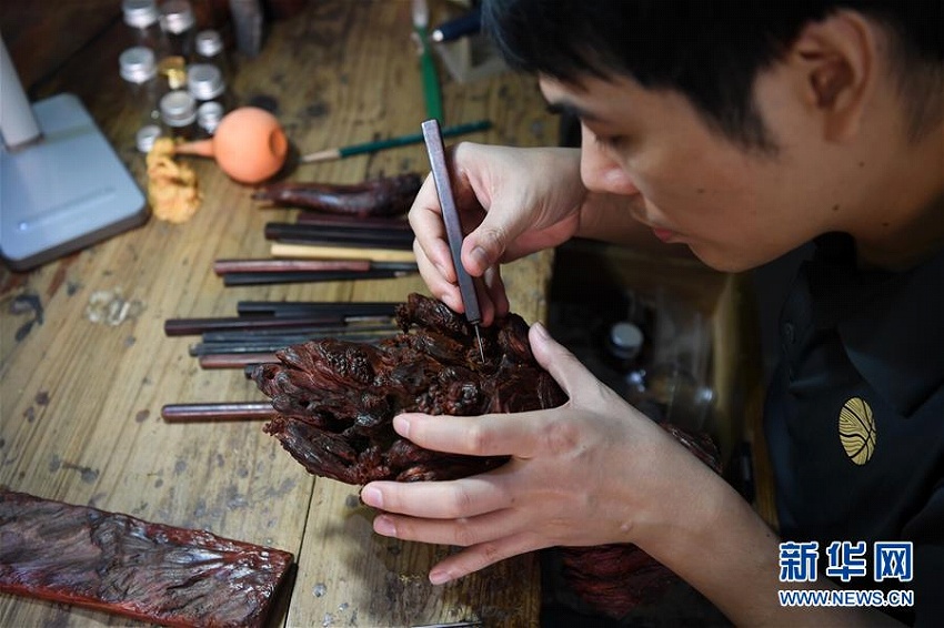 夫婦仲良く彫刻刀を手に無形文化財の木彫刻技法を伝承