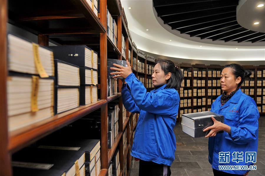 12月13日、展示室で「線裝本」を整理する?yún)覙蚪鸲诺浼∷⒐訾巫鳂I(yè)員。