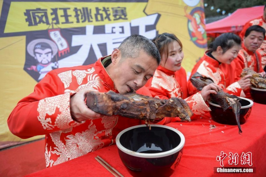 燻製食品大食い大會で王座目指し燻製魚にかぶりつく女性　中國