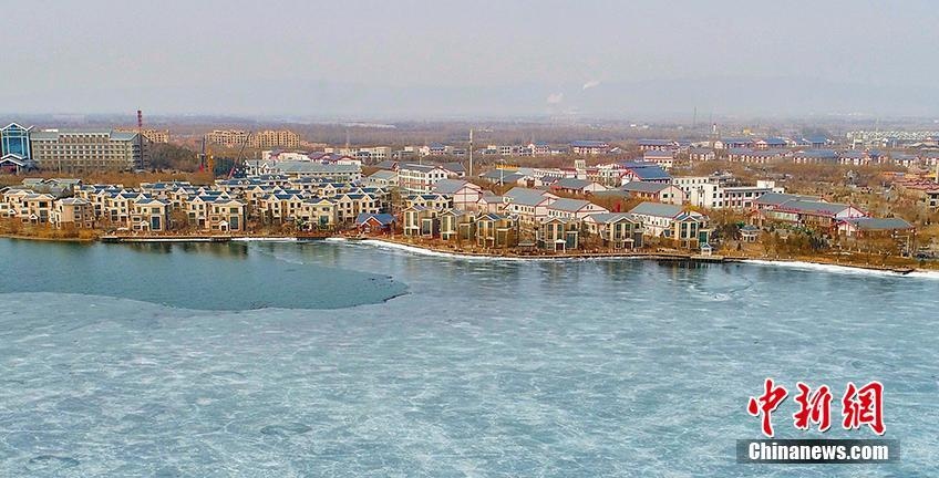 「寒の戻り」で美しい水色に凍った張掖國家濕地公園の湖　甘粛省