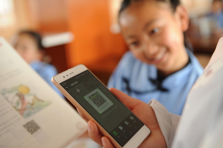 2017年4月14日、安徽省合肥市包河區(qū)葛大店小學(xué)校の國學(xué)教室では、國學(xué)の擔(dān)當(dāng)教員が、教科書上のQRコードをスマホで読み取り、アナウンサーが朗読する中國古典のオーディオ放送を生徒に聴かせる様子（撮影?張洪金）。