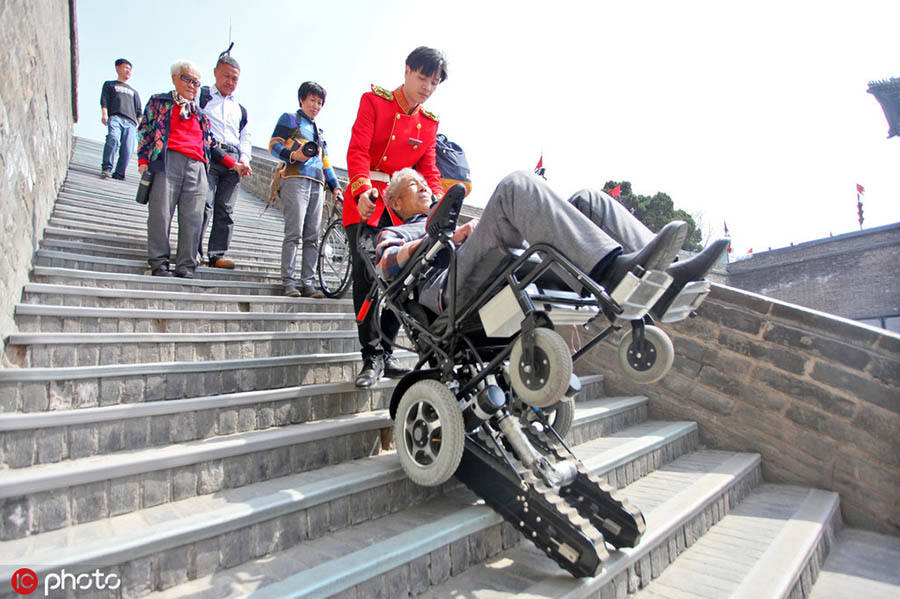 係員が車いす用階段昇降機(jī)を使用して高齢者を運(yùn)ぶ様子（東方IC が畫像の著作権所有。転載禁止）。