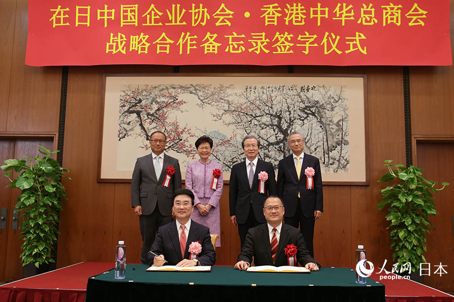 在日本中國大使館の程永華大使、林鄭月娥?香港特區(qū)行政長官、中央政府駐香港連絡(luò)弁公室経済部の劉亜軍副部長、在日本中國大使館の宋耀明経済商務(wù)公使が見守る中、「在日中國企業(yè)協(xié)會?香港中華総商會戦略提攜覚書」の調(diào)印を行う在日中國企業(yè)協(xié)會の王家馴會長と香港中華総商會の蔡冠深會長（撮影?木村雄太）。