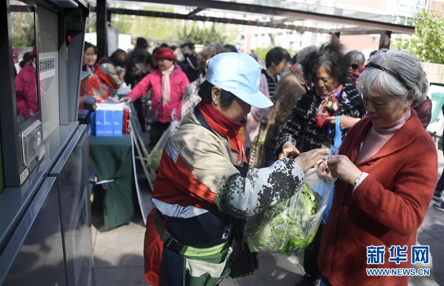 ゴミ分類の指導員のサポートを受けながら、スマート分類ゴミ箱の使い方を學ぶ住民たち（撮影?李欣）。