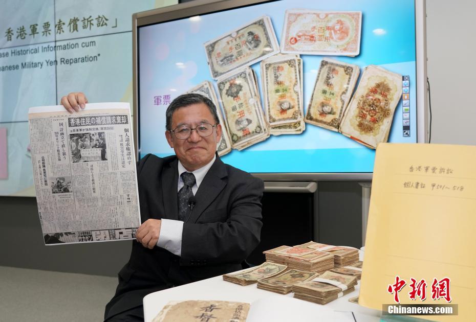 「香港軍票訴訟」関連の歴史資料を見(jiàn)せる和仁廉夫氏 (撮影?張■、■は火へんに韋)。