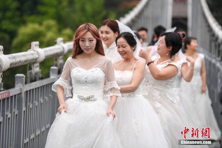 湖南省、女性労働者がウェディングドレスを著てガラスの吊り橋に集合