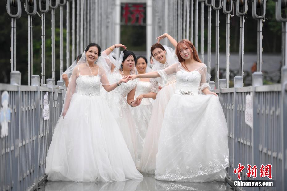 湖南省、女性労働者がウェディングドレスを著てガラスの吊り橋に集合