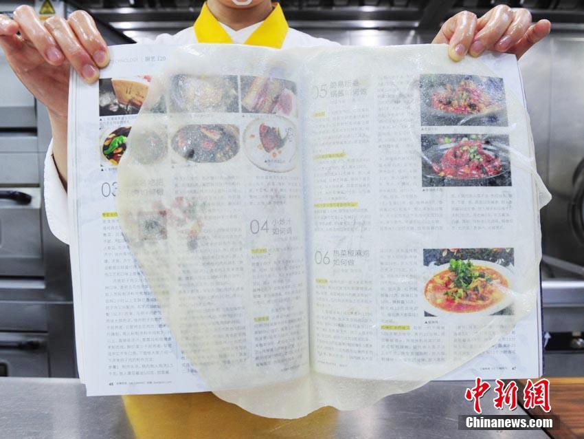 油紙ほどの薄さの皮の厚さは平均0.02ミリ。雑誌や新聞の上に置いても、文字や寫真がはっきりと見える（撮影?劉棟）。