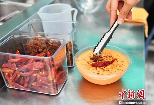 火鍋ヨーグルトに八角をのせて、最後のトッピング（撮影?安源）。