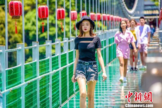 下段の一部が吹き抜けとなっているガラスのつり橋で「恐る恐る一歩を踏み出す」モデルたち（撮影?王東明）。